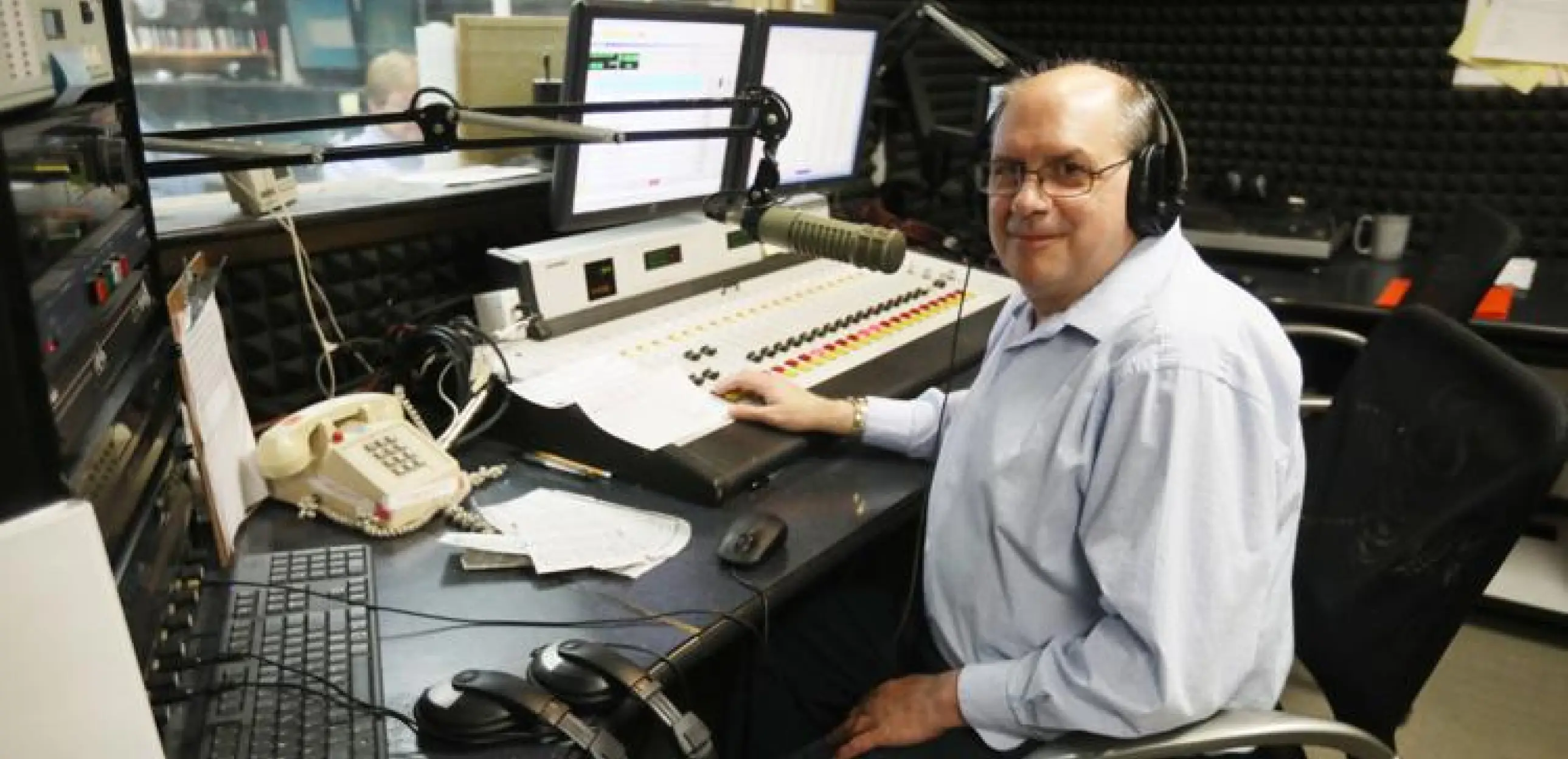 Paul Trama sitting at a radio station desk